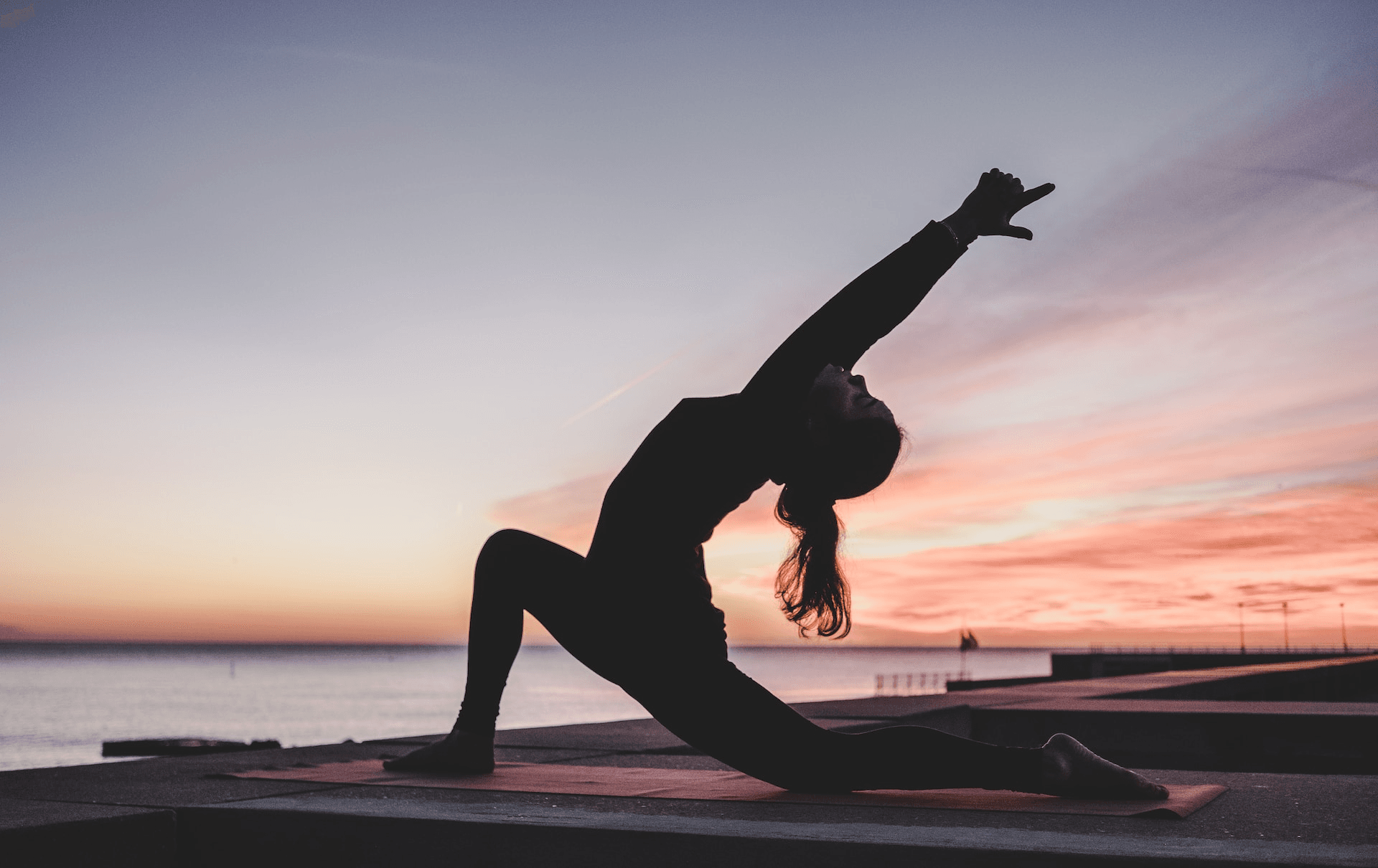 Woman Doing Yoga Stretch Near Ocean Sunset